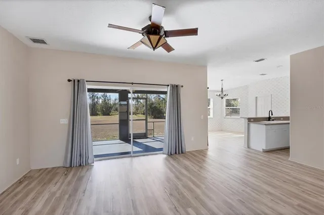 a large white kitchen with stainless steel appliances kitchen island granite countertop a sink and cabinets