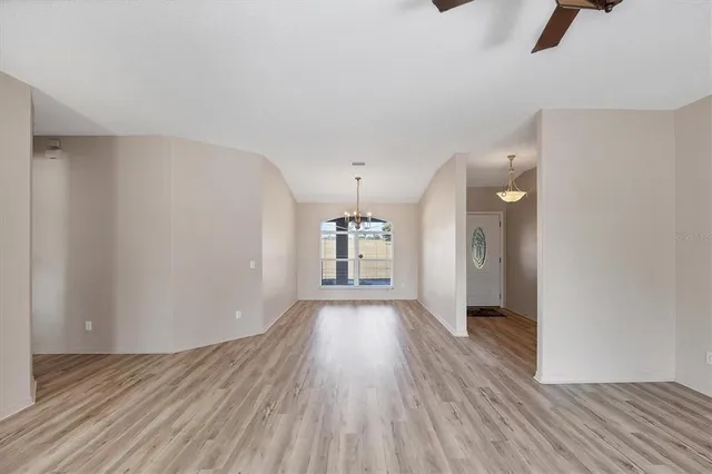 a large kitchen with a refrigerator a sink dishwasher and a stove with wooden floor