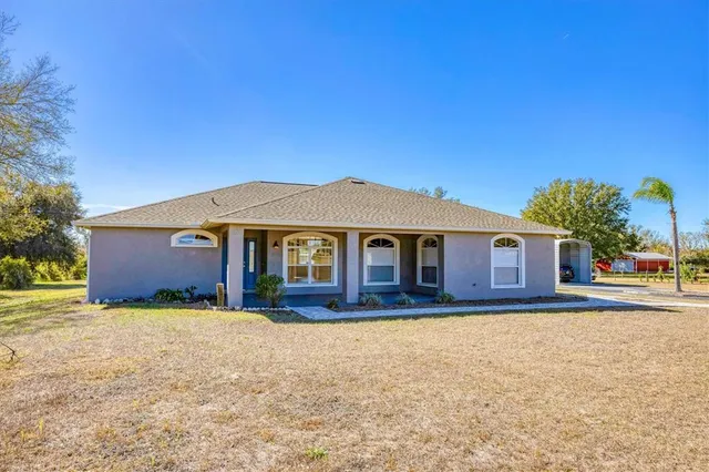 a front view of house with yard and trees in the background