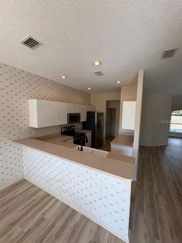 a view of a livingroom with wooden floor and furniture