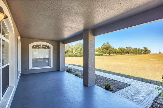an empty room with wooden floor closet and windows