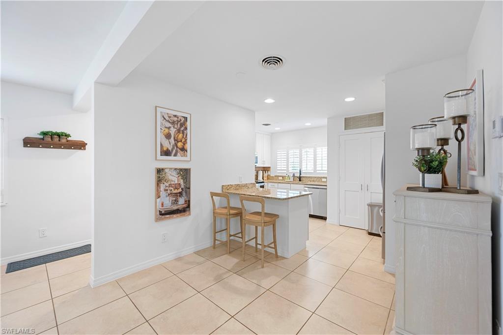 1340 Crayton Road, Unit 4 Naples, FL 34102 - Photo 17 of 22 Kitchen featuring a kitchen breakfast bar, a peninsula, light tile patterned flooring, recessed lighting, and stainless steel dishwasher