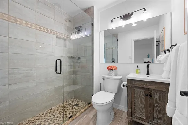 a bathroom with a sink a toilet and shower