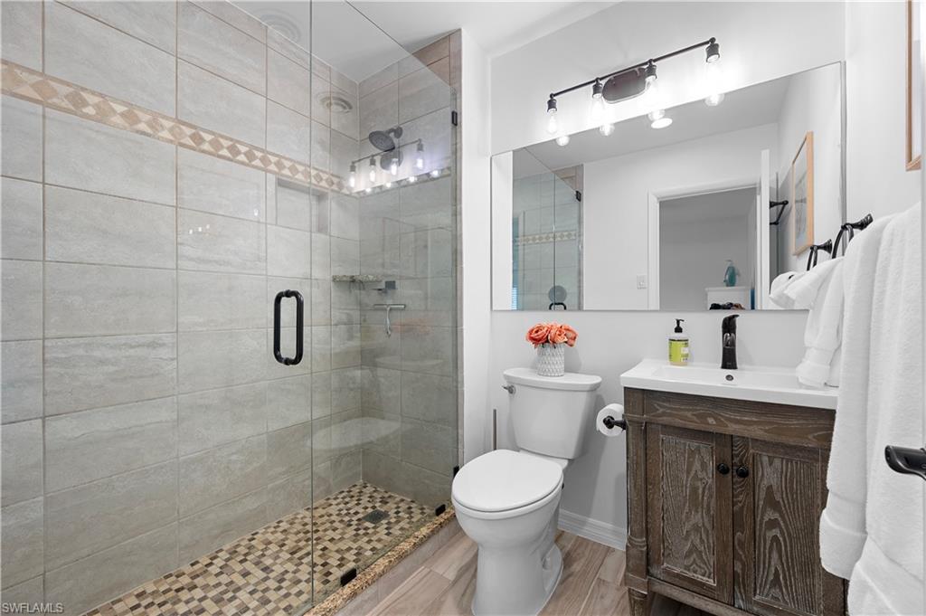 1340 Crayton Road, Unit 4 Naples, FL 34102 - Photo 9 of 22 Bathroom featuring vanity, a stall shower, and light wood-style floors