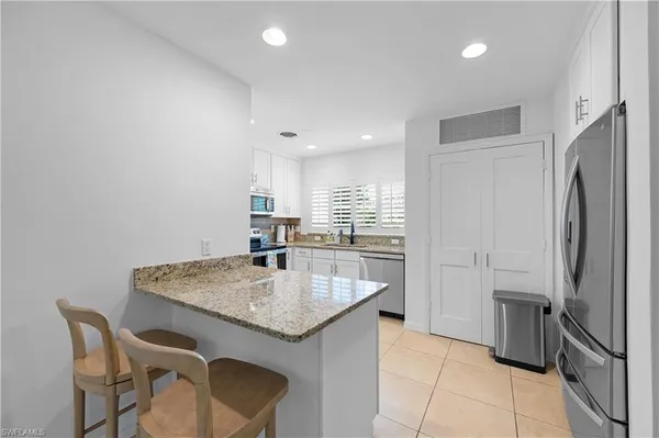 a kitchen with a table chairs refrigerator and microwave