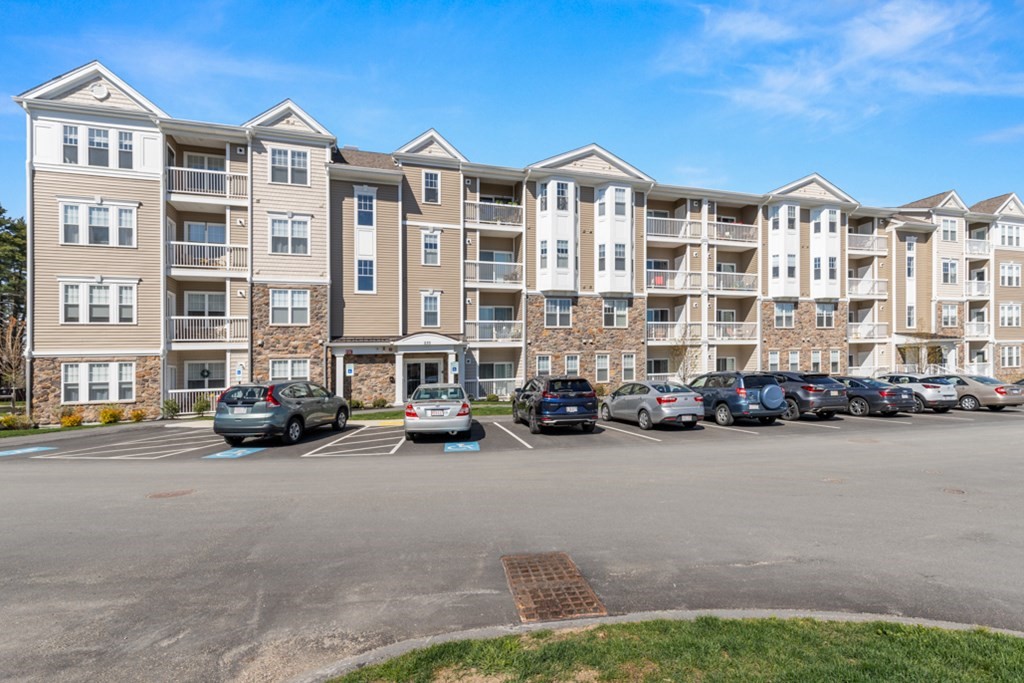 230 Martins Landing, Unit 201 North Reading, MA 01864 - Photo 1 of 30 a view of a street with cars and a buildings in the background