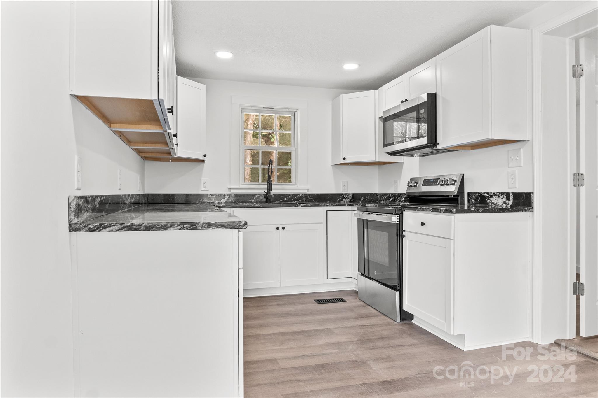 4879 Joe Powell Road Morganton, NC 28655 - Photo 13 of 35 a kitchen with stainless steel appliances granite countertop a stove a sink and a microwave