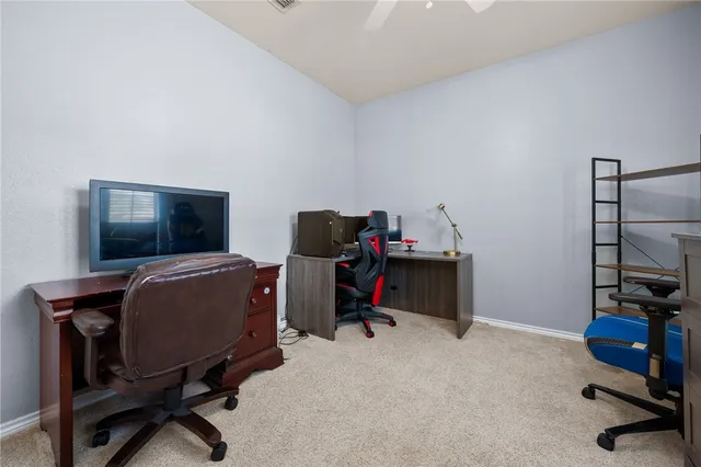 a view of a workspace with furniture and a window