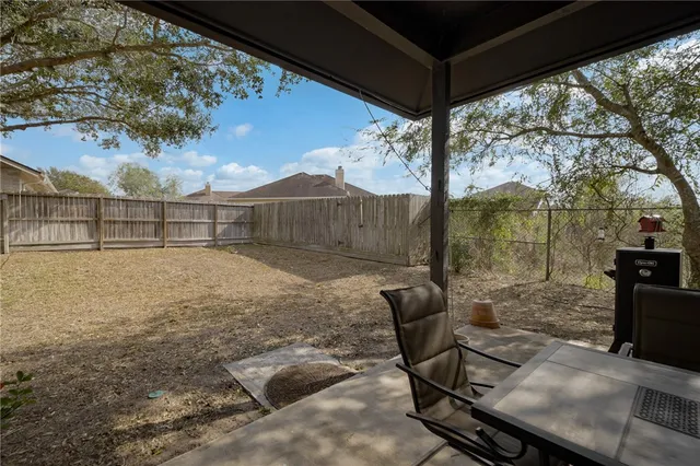 a backyard of a house with table and chairs