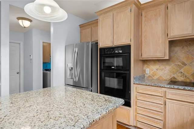 a kitchen with stainless steel appliances granite countertop a refrigerator and a stove top oven