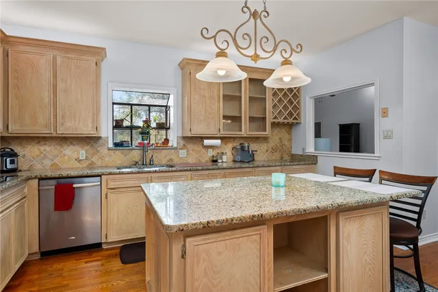 a kitchen with granite countertop stainless steel appliances a sink stove and cabinets