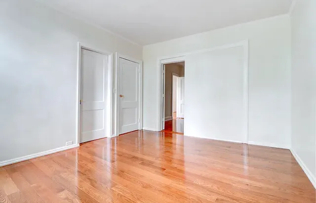 a view of an empty room with wooden floor