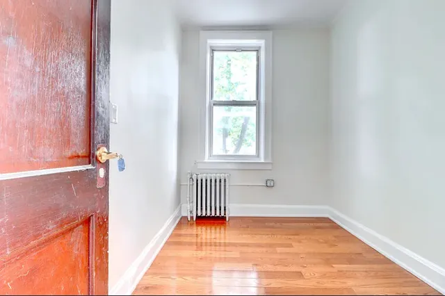 a view of a room with wooden floor and a window