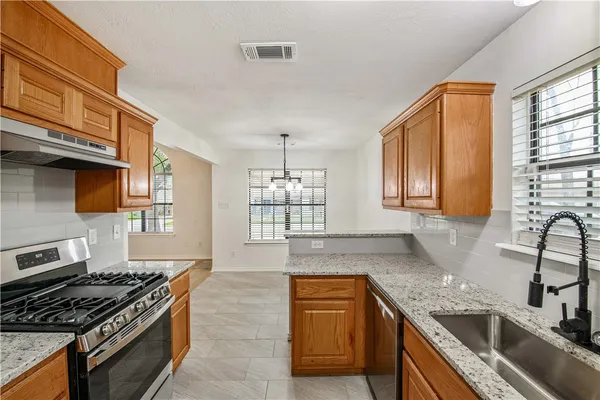 a kitchen with granite countertop a stove and a sink