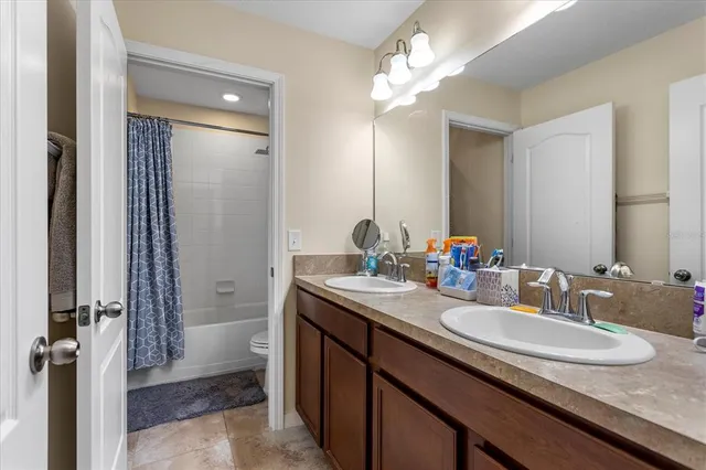 a bathroom with a granite countertop sink a mirror and a shower