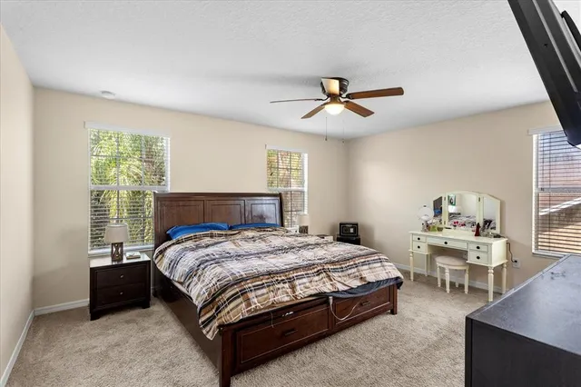a bedroom with a bed a chandelier and dresser