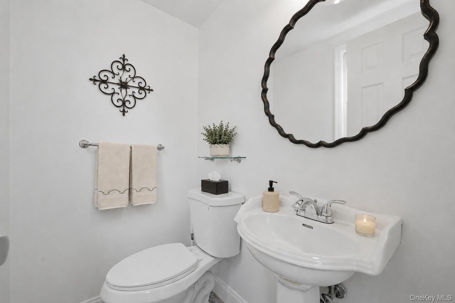 144 Bell Road Scarsdale, NY 10583 - Photo 17 of 49 Half bath with pedestal sink with chrome faucet, complemented by a decorative black-framed mirror