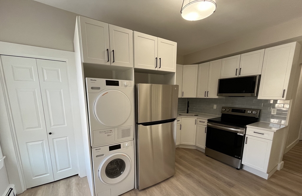 17 M Street Boston, MA 02127 - Photo 3 of 10 a kitchen with stainless steel appliances granite countertop a refrigerator and a stove top oven