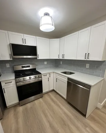 a kitchen with granite countertop a stove and a microwave