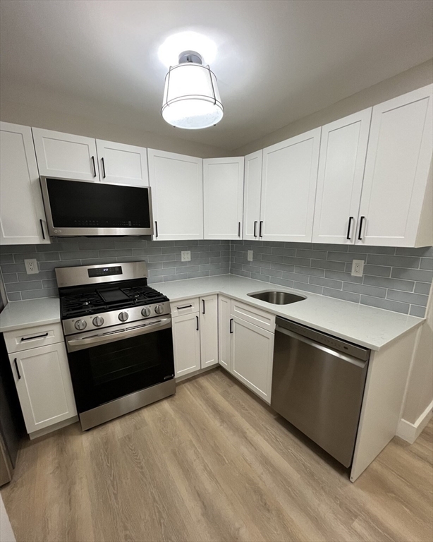 17 M Street Boston, MA 02127 - Photo 8 of 10 a kitchen with granite countertop a stove and a microwave