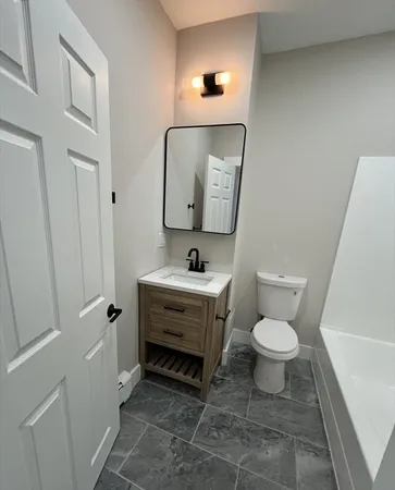 a bathroom with a toilet sink and mirror
