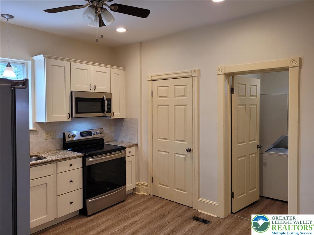 1024 Delaware Avenue, Unit 1 Bethlehem, PA 18015 - Photo 10 of 17 a kitchen with stainless steel appliances white cabinets and wooden floor