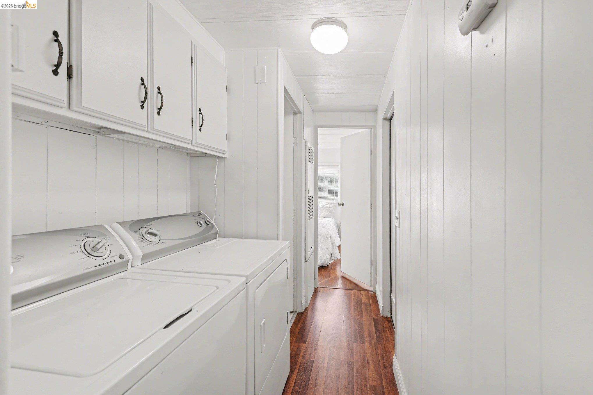 36 Cayuga Street Oakley, CA 94561 - Photo 17 of 25 Laundry area with dark wood-type flooring, washer and dryer, cabinet space, and wooden walls