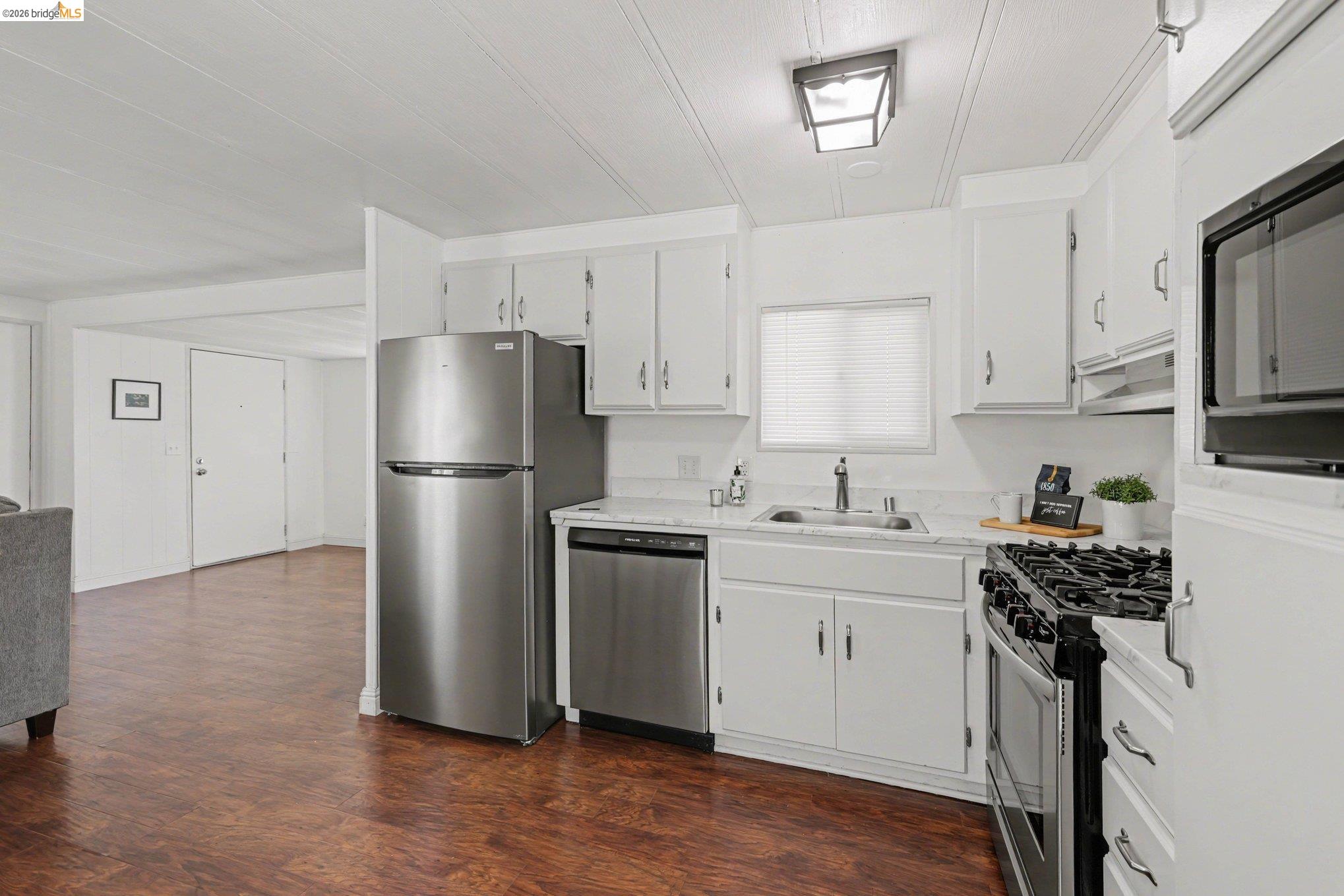36 Cayuga Street Oakley, CA 94561 - Photo 9 of 25 Kitchen featuring light countertops, stainless steel appliances, dark wood-style floors, and white cabinetry