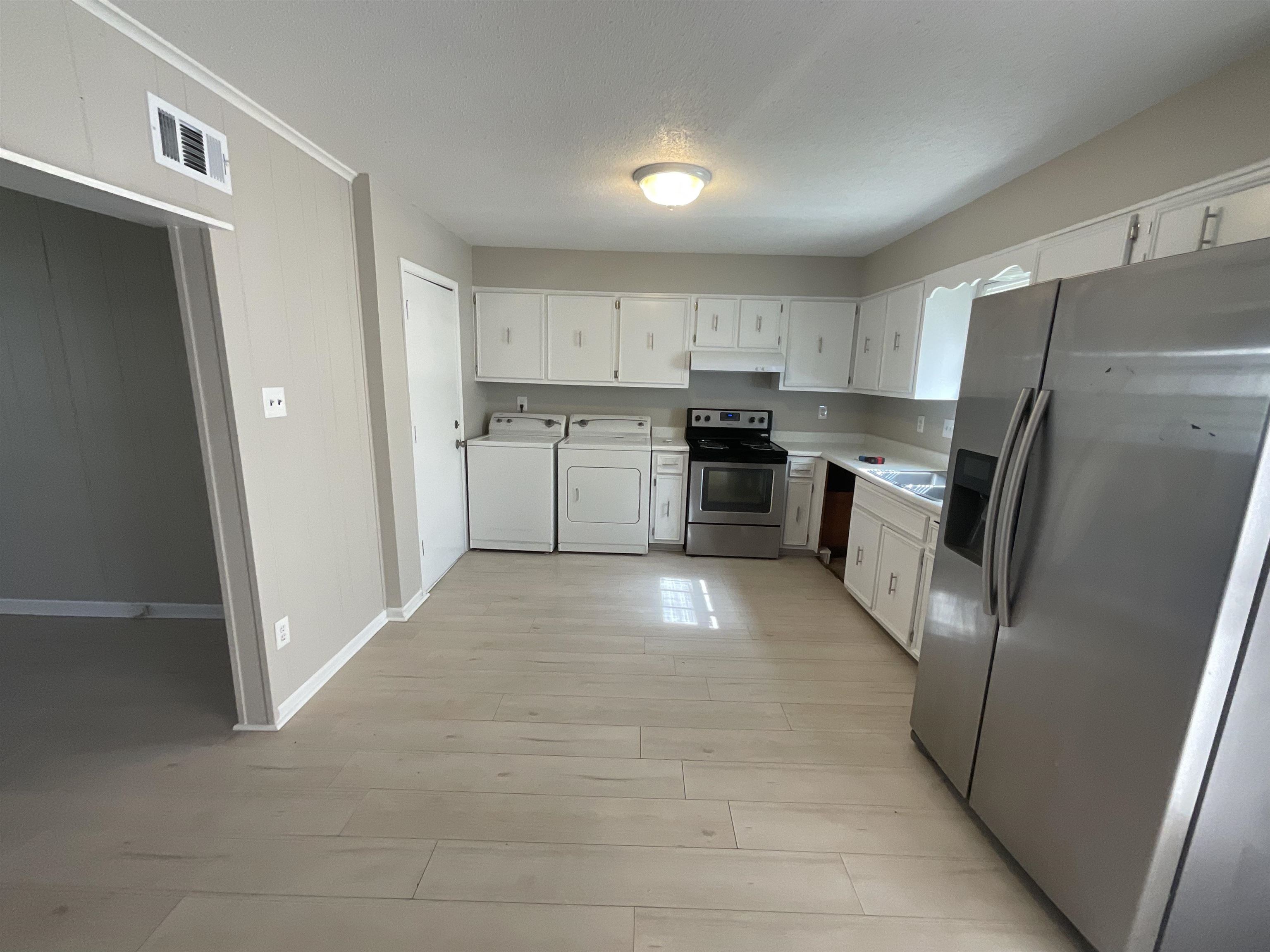 3193 Rendezvous Lane Memphis, TN 38118 - Photo 19 of 24 a kitchen with a refrigerator a stove top oven and white cabinets
