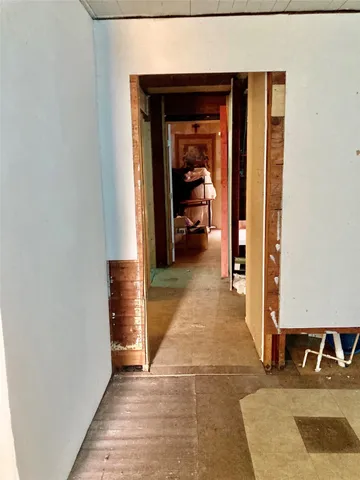 a view of a hallway with wooden floor and a living room