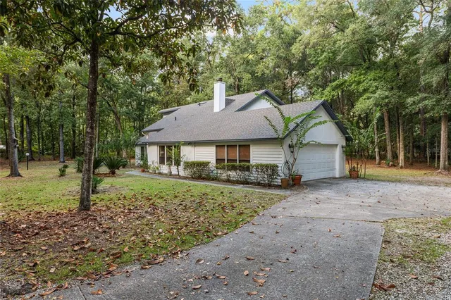 a view of an empty room with windows & stairs