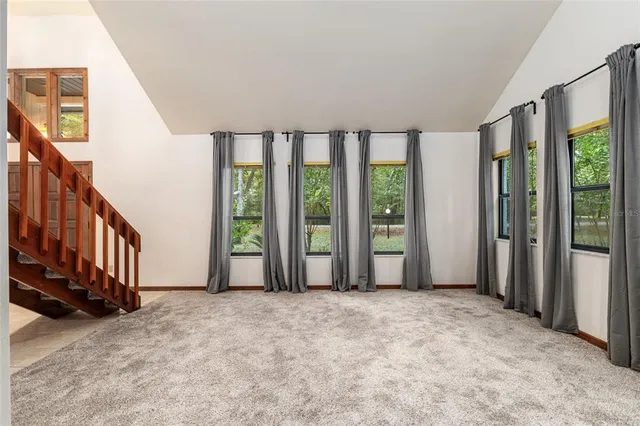 an empty room with windows and fireplace