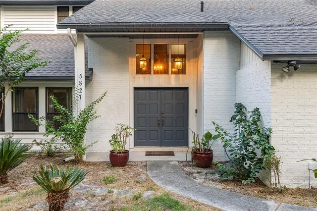 a backyard of a house with table and chairs under an umbrella