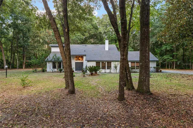 a view of a house with a yard and large tree