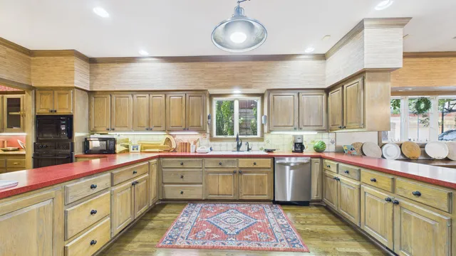 a kitchen with stainless steel appliances granite countertop lots of counter top space and wooden floor