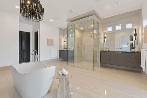 a bathroom with a tub shower sink and mirror