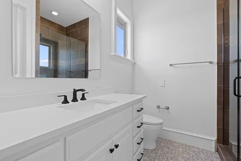 a bathroom with a sink a toilet and mirror