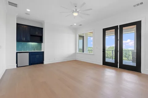 a view of an empty room with window and cabinet