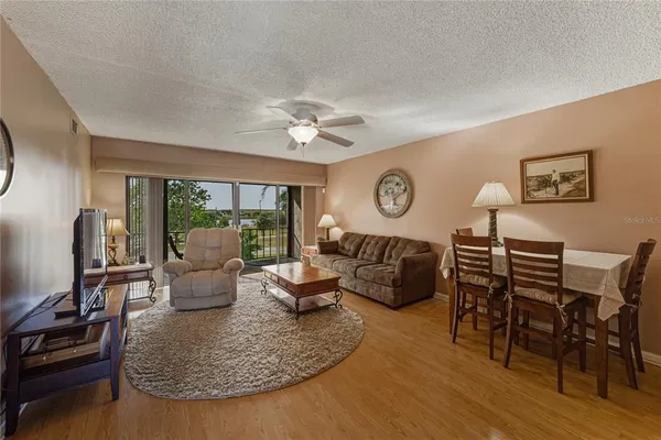 a living room with furniture kitchen view and a large window