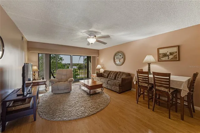 a living room with furniture kitchen view and a large window