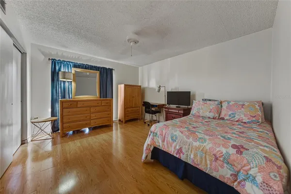 a bedroom with a bed and wooden floor