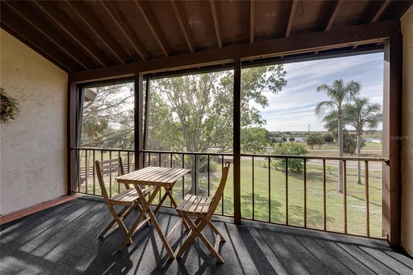 a view of a two room with wooden floor and furniture