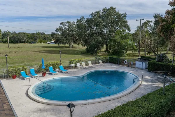 a view of a swimming pool with outdoor seating and garden