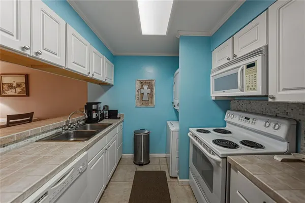 a kitchen with granite countertop a sink a stove and cabinets