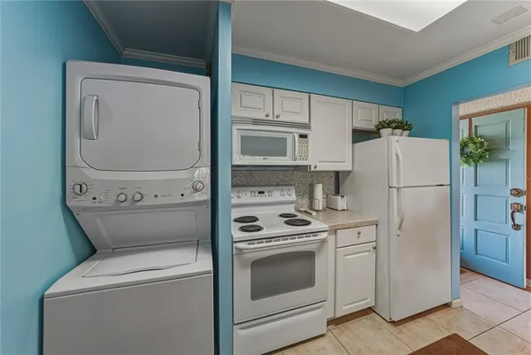 a kitchen with refrigerator a stove and white cabinets