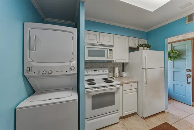 a kitchen with refrigerator a stove and white cabinets