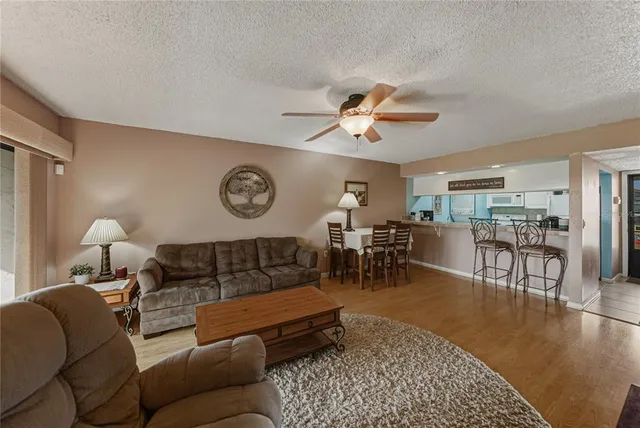 a living room with furniture a clock on wall and a table