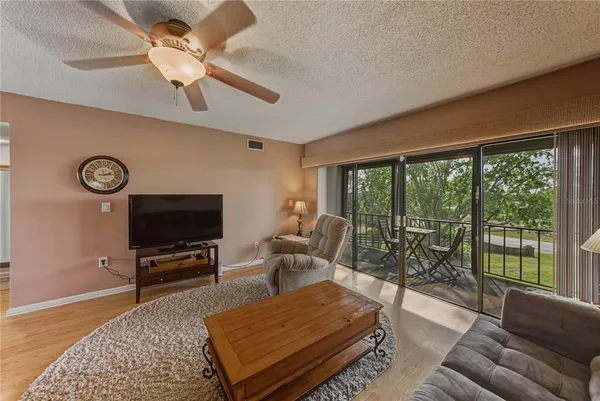 a living room with furniture a ceiling fan and a flat screen tv