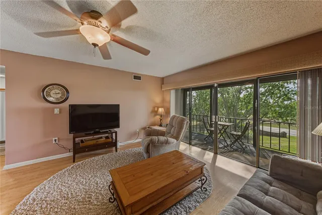 a living room with furniture a ceiling fan and a flat screen tv