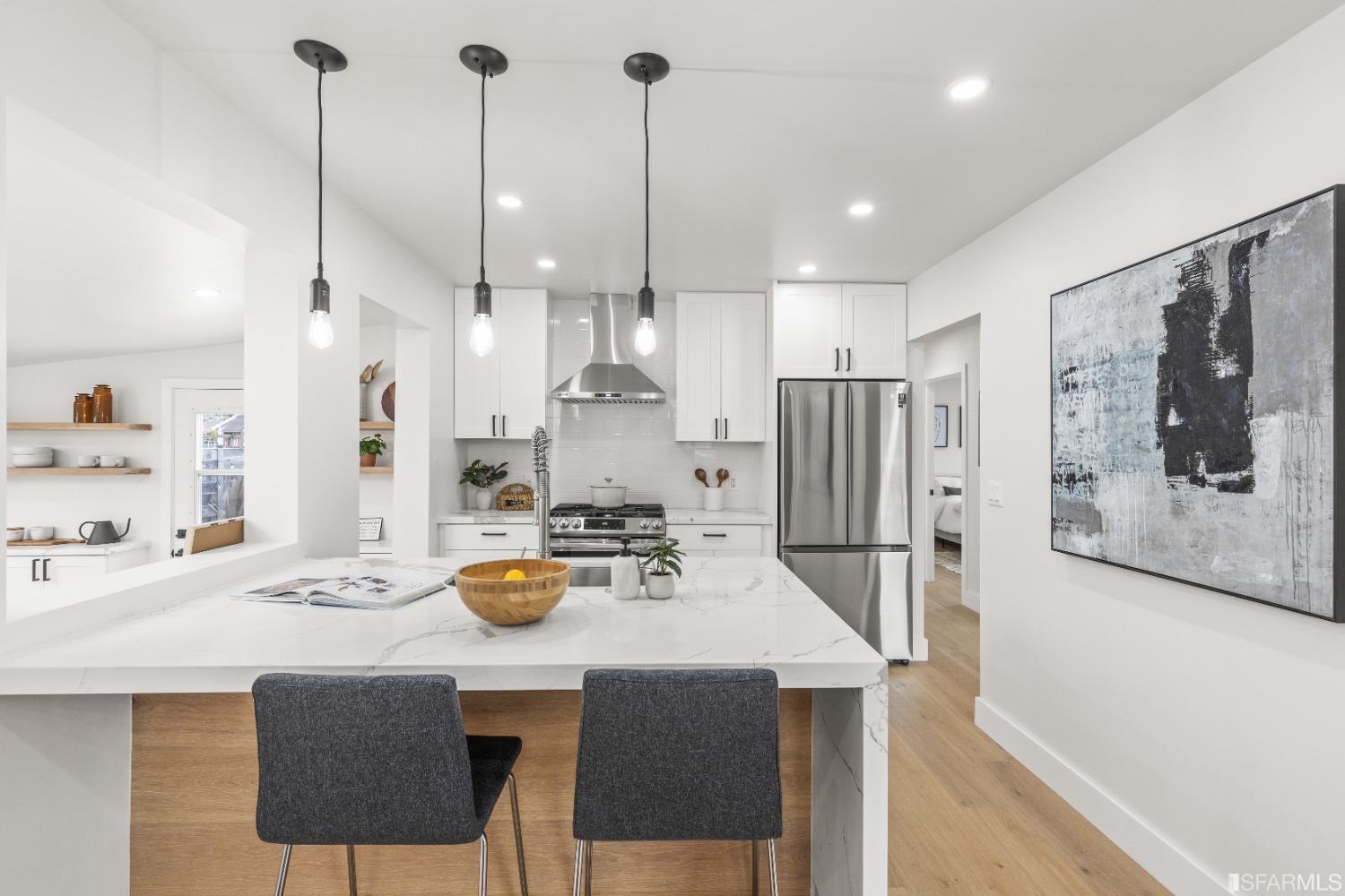 1139 Peralta Road Pacifica, CA 94044 - Photo 9 of 58 a kitchen with stainless steel appliances kitchen island granite countertop a dining table chairs and white cabinets